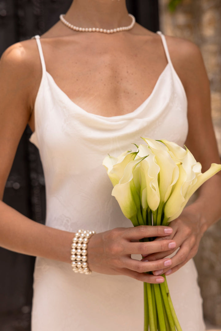 Woman wearing a white sleeveless slip dress with a V-neckline and maxi length