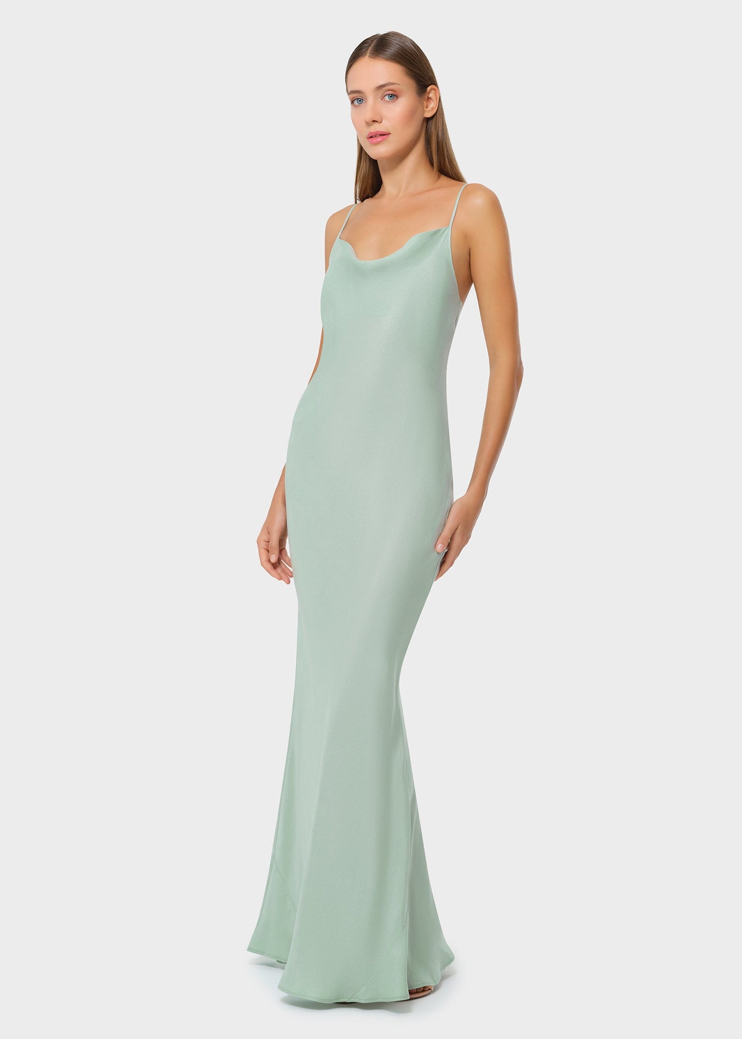 Woman wearing mint green vegan silk slip maxi dress, side view