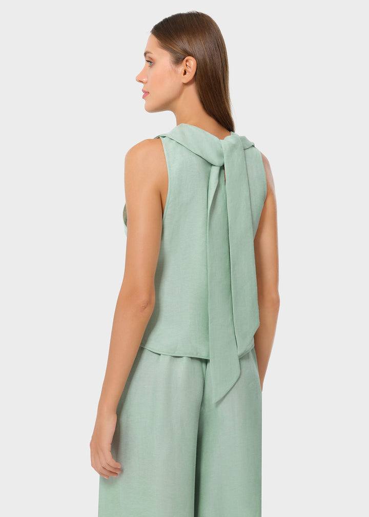 Back and side view of a woman wearing a mint sleeveless top with a long tie detail draping down the back, paired with matching wide-leg pants, shown in a studio setting.