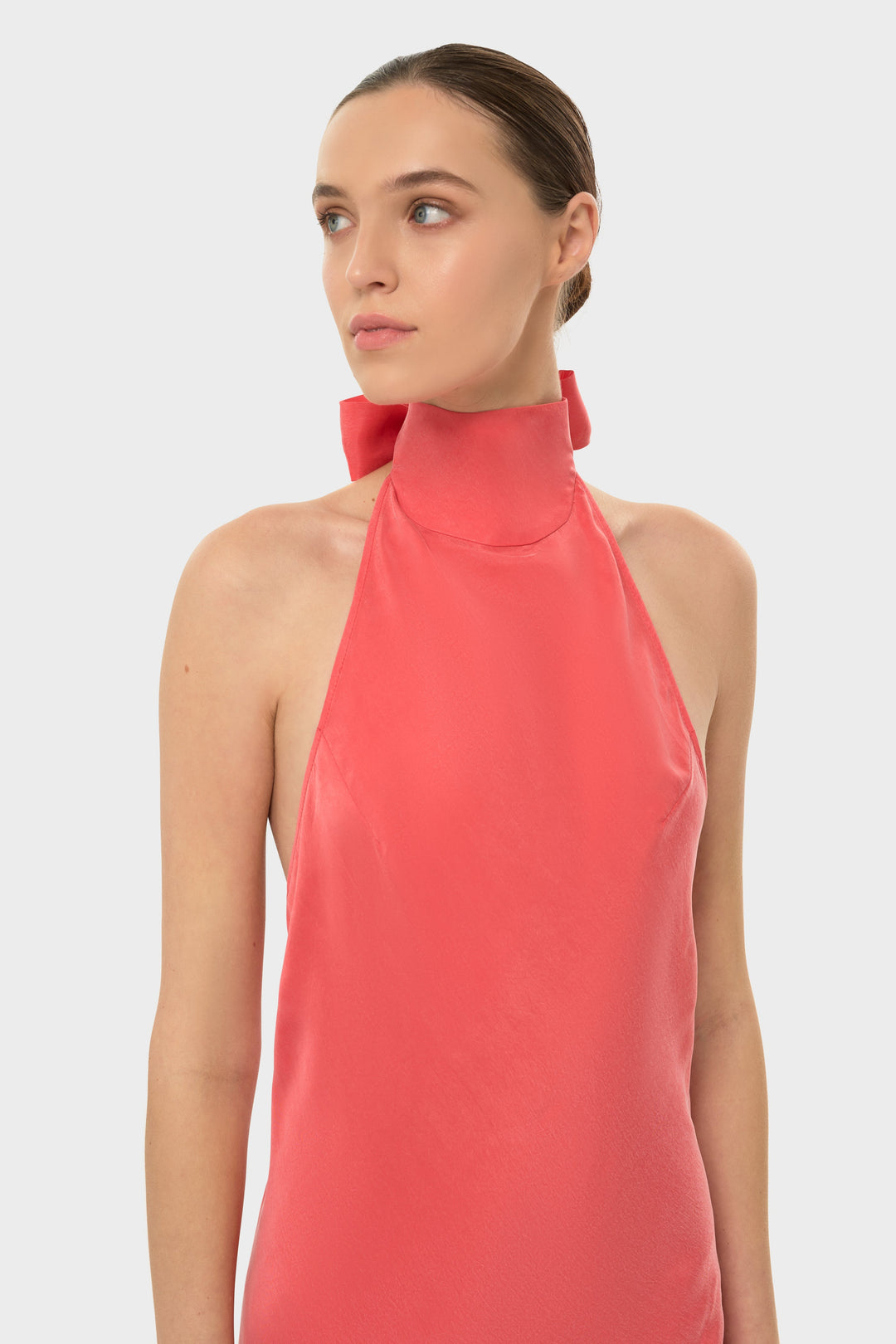 Woman in a coral halter maxi dress.