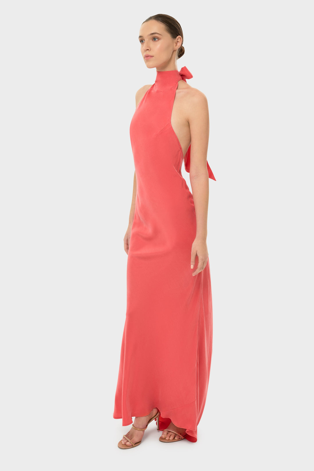 Woman in a coral halter maxi dress.