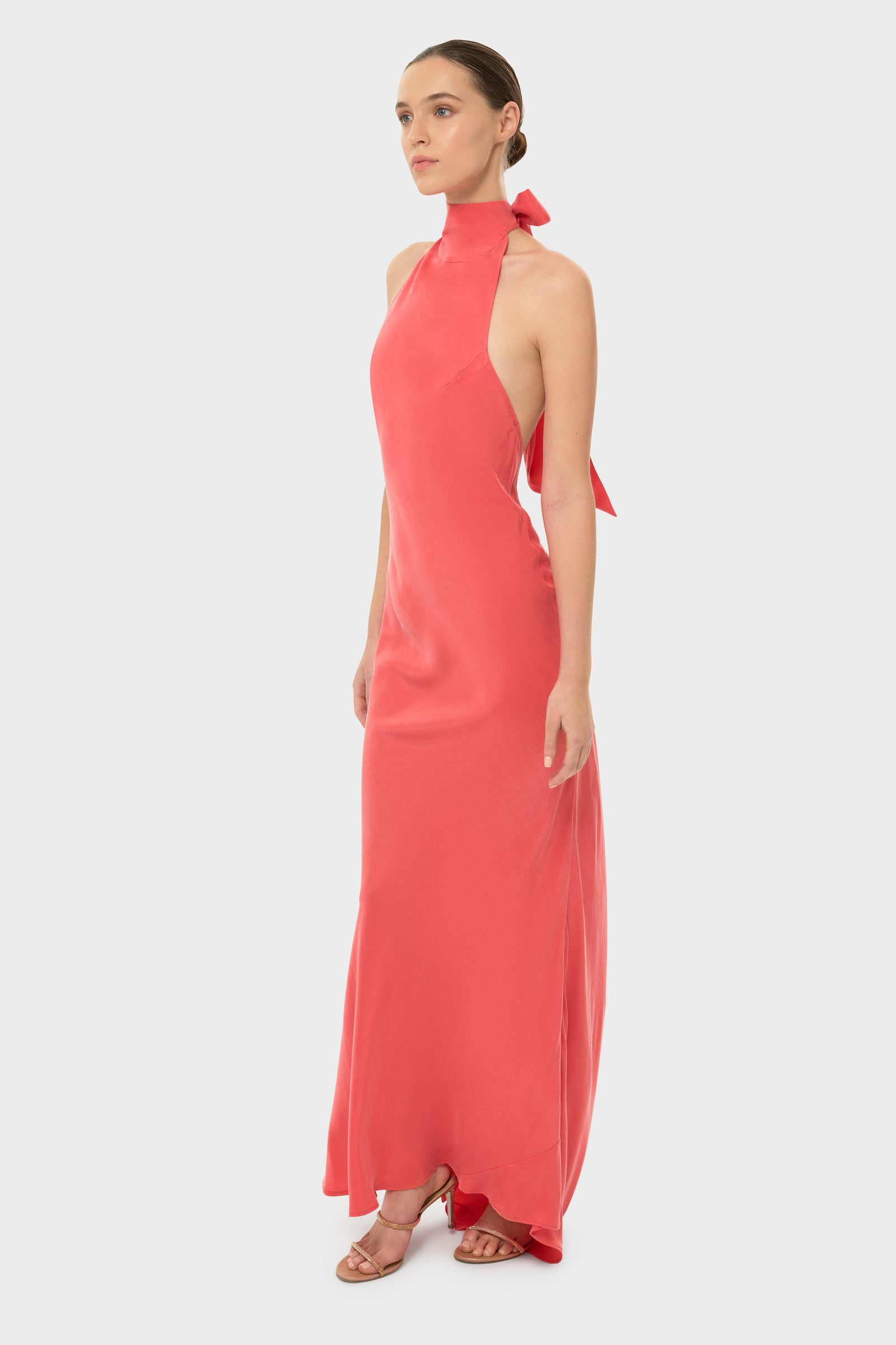 Woman in a coral halter maxi dress.