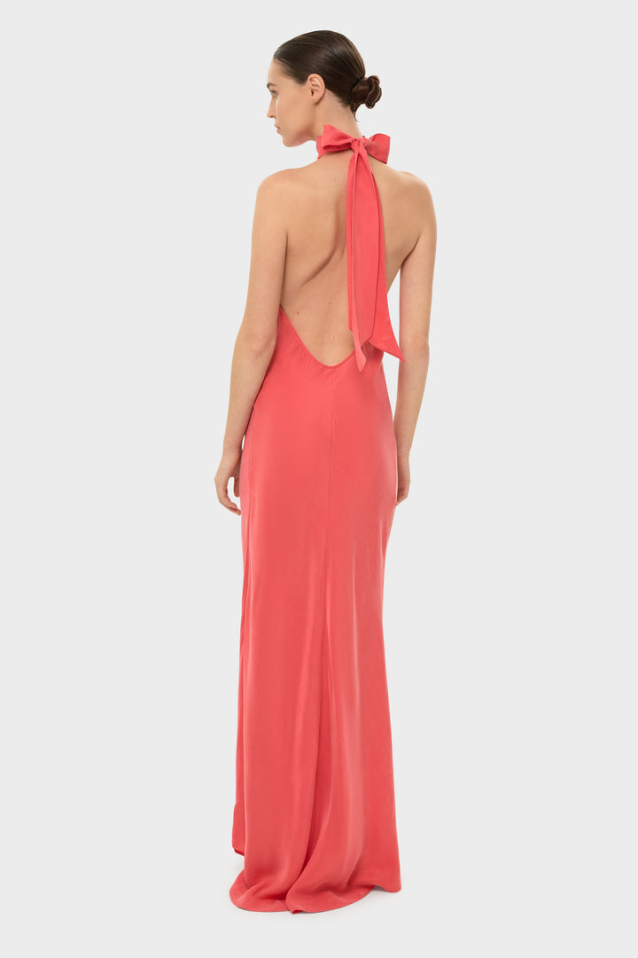 Woman in a coral halter maxi dress.
