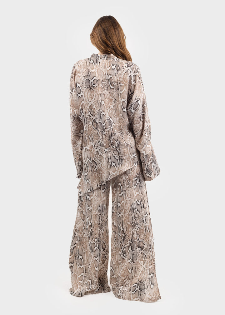 Woman wearing a gray and white snake print tunic top with matching snake print wide-leg pants