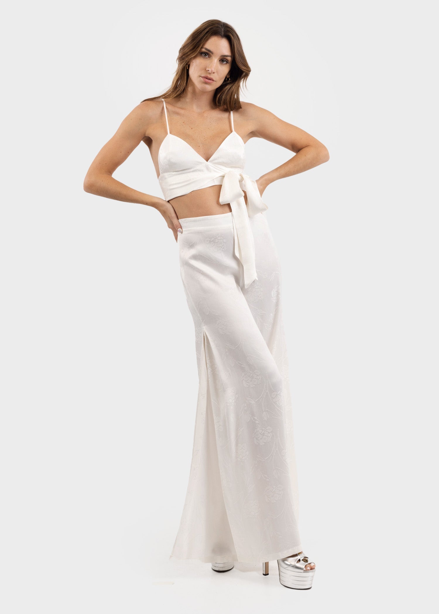 Woman wearing white wide-leg flared pants with a flowing silhouette