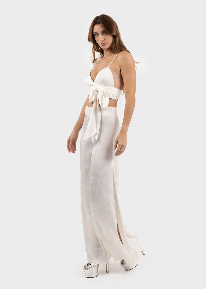 Woman wearing white wide-leg flared pants with a flowing silhouette