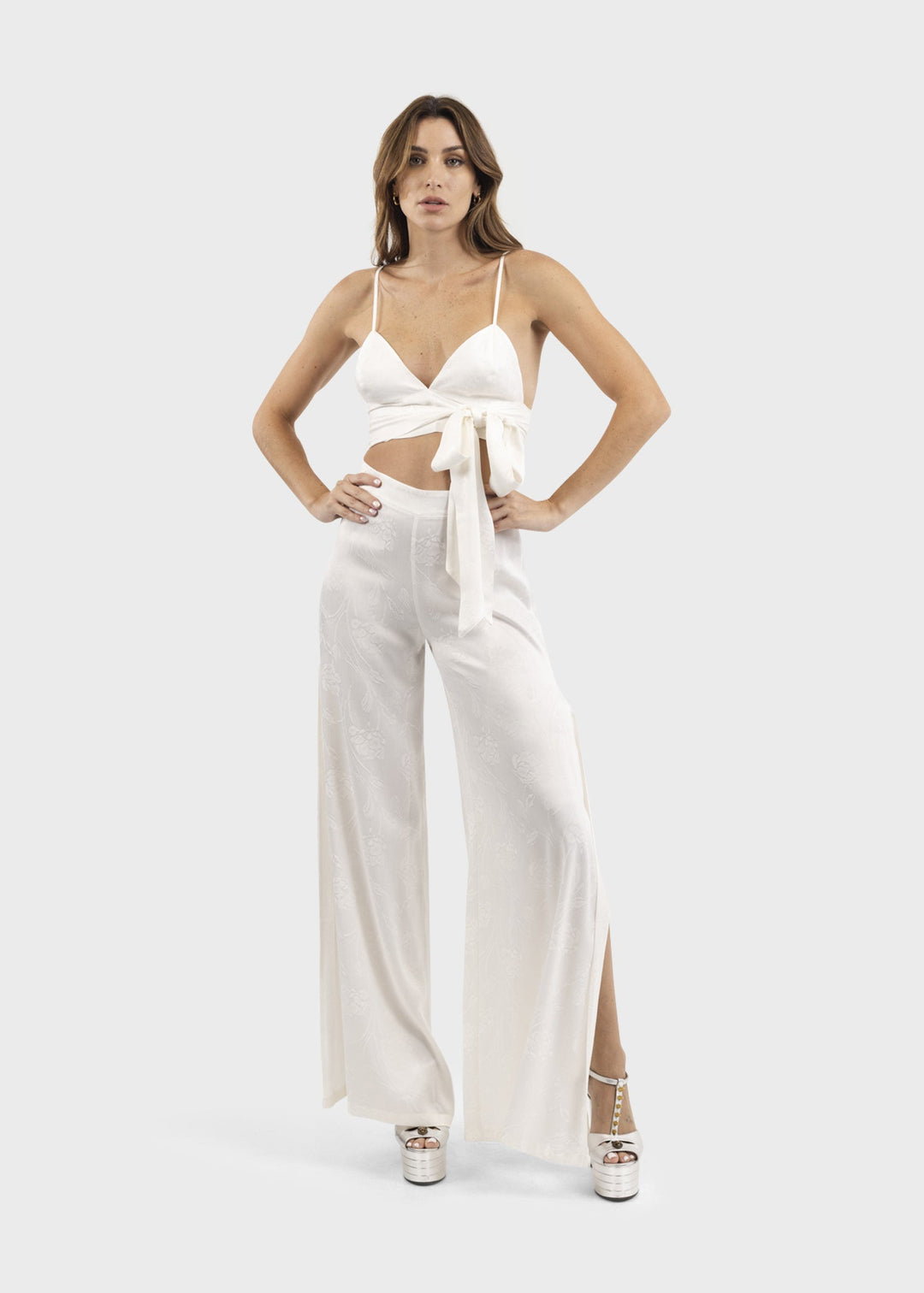 Woman wearing white wide-leg flared pants with a flowing silhouette