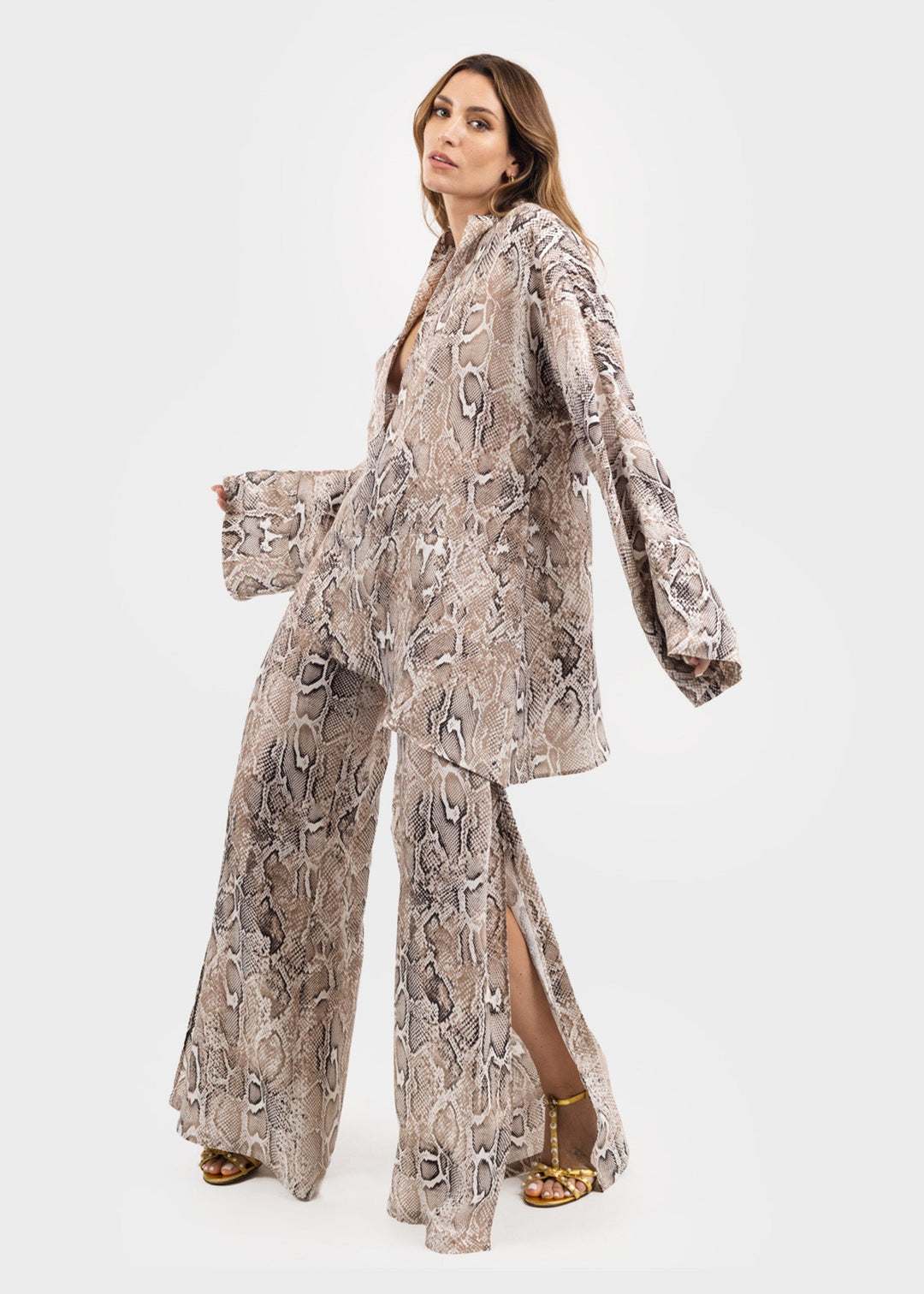 Woman wearing a gray and white snake print tunic top with matching snake print wide-leg pants