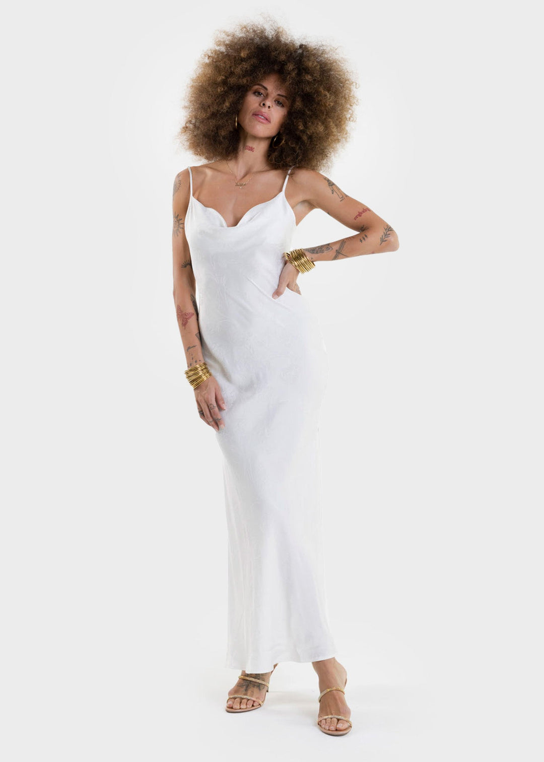Woman wearing a white sleeveless slip dress with a V-neckline and maxi length