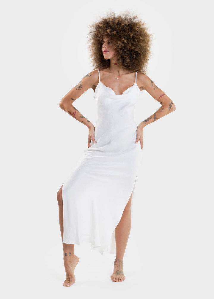 Woman wearing a white sleeveless slip dress with a V-neckline and maxi length